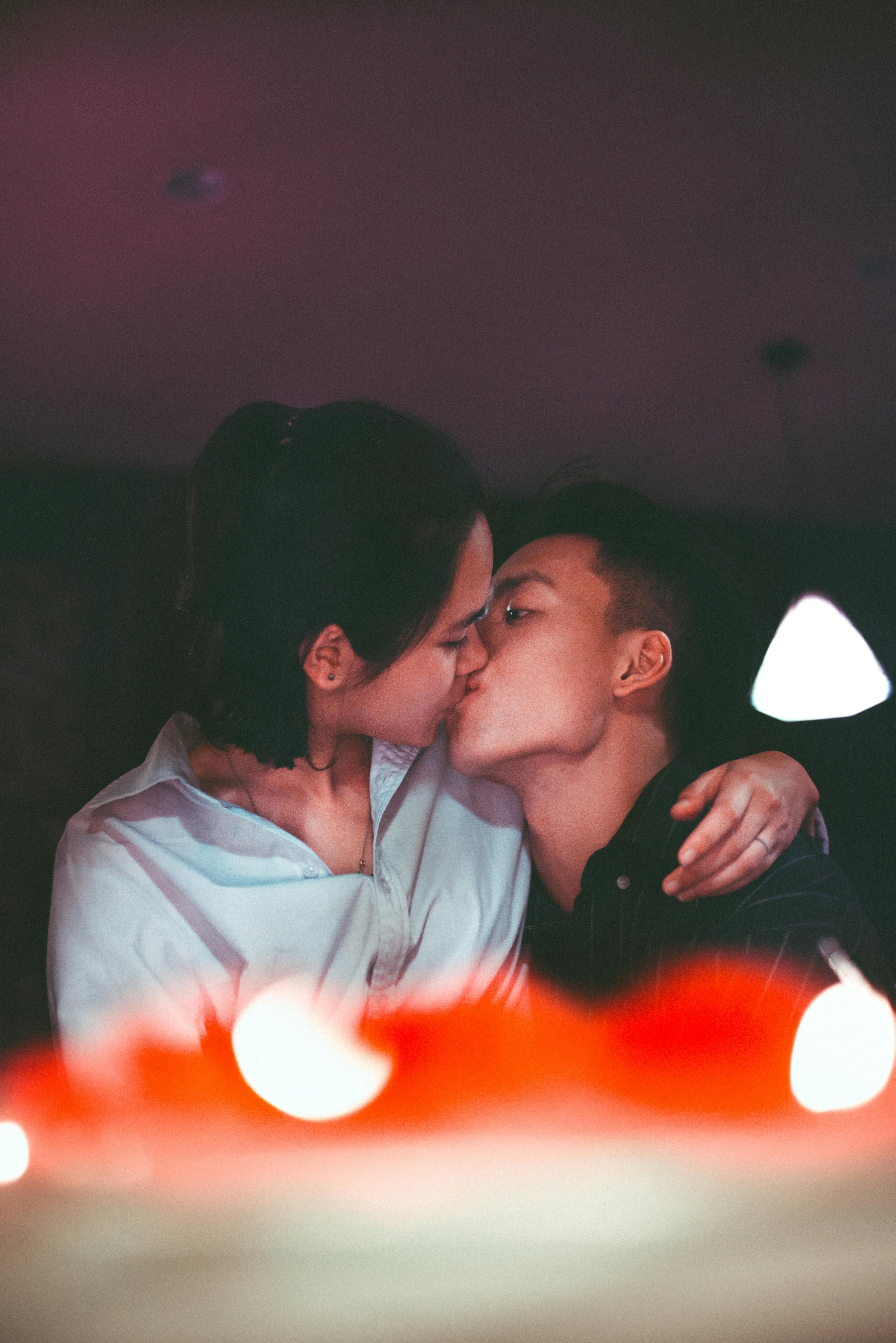 Paar küsst sich bei Kerzenlicht auf einem romantischen Date